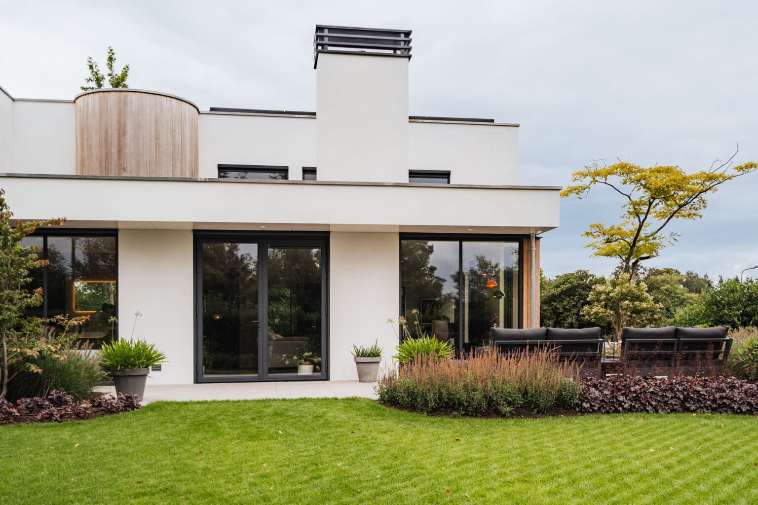 Achtergevel van de villa met terras en schuifpuien over de volle breedte