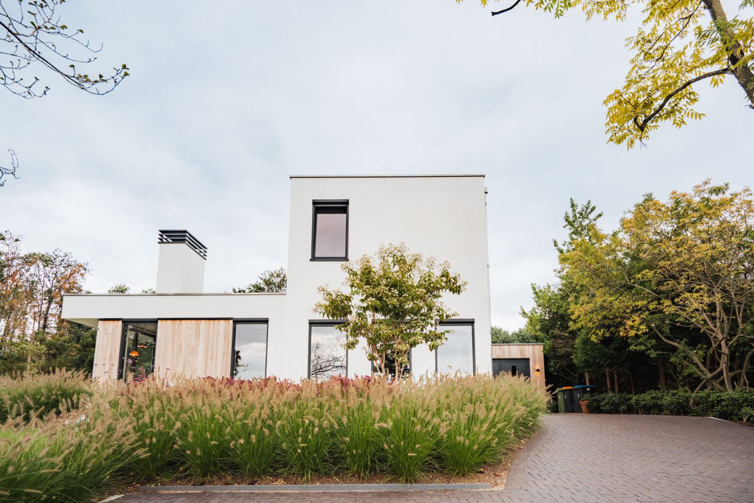 Voorgevel van de villa in Leersum met siergrassen langs de oprit