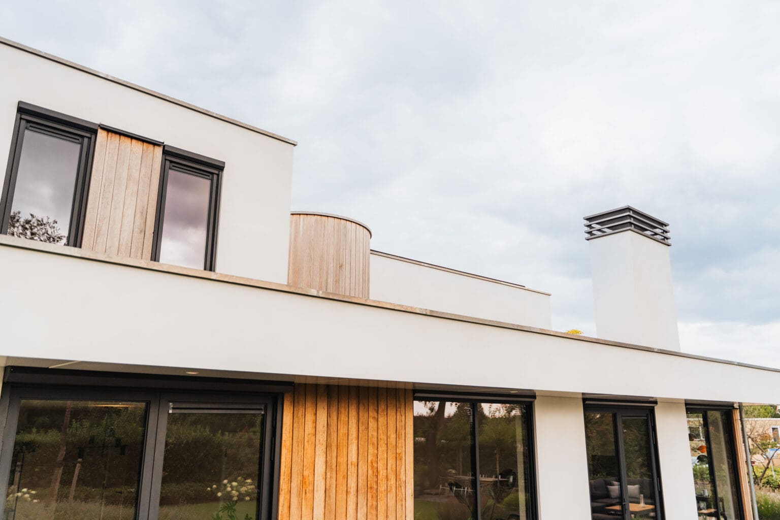 Bovenbouw met houten gevelbekleding en donkere aluminium kozijnen