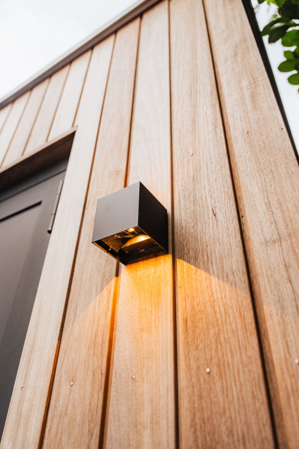 Wandlamp op de houten gevel in de avondschemering