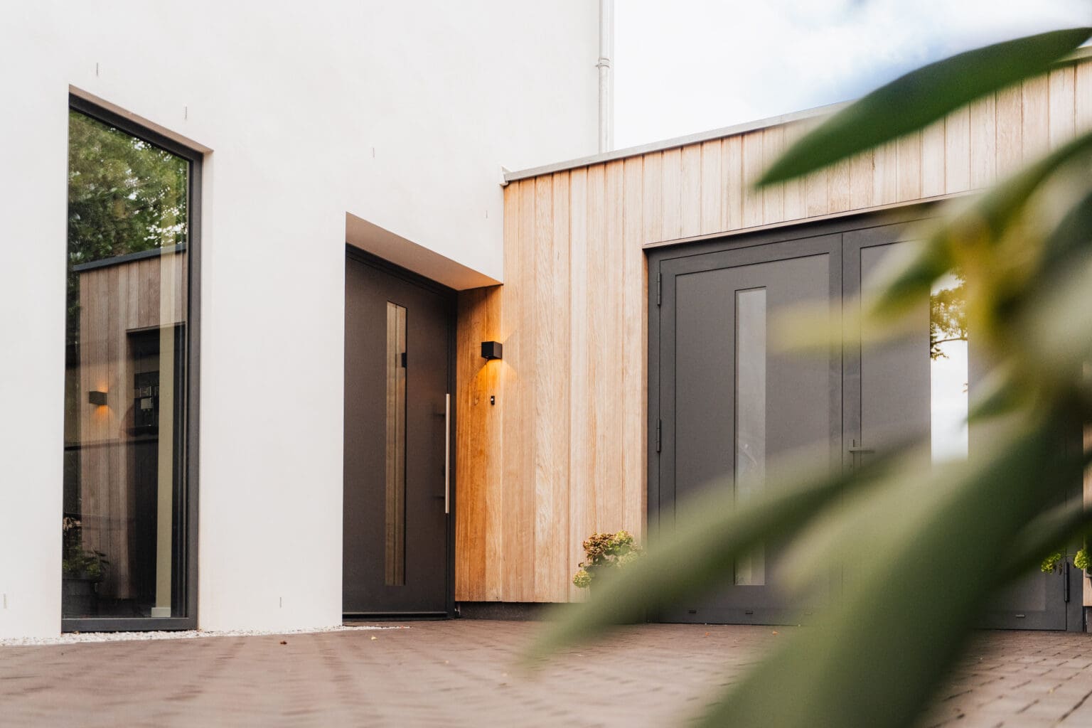 Houten voordeur van de villa naast de garagedeur