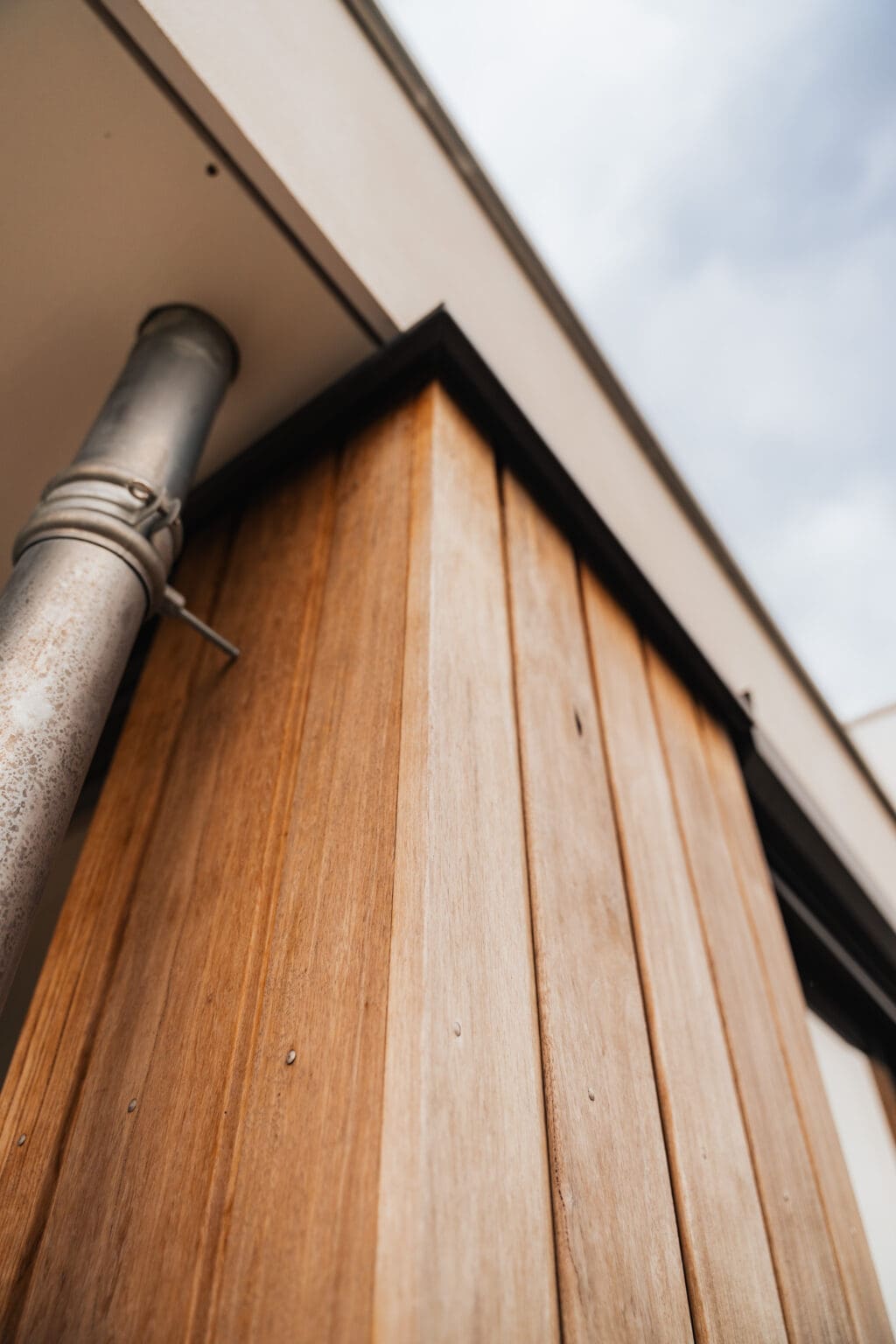 Detail van de verticale houten gevelbekleding langs de dakrand