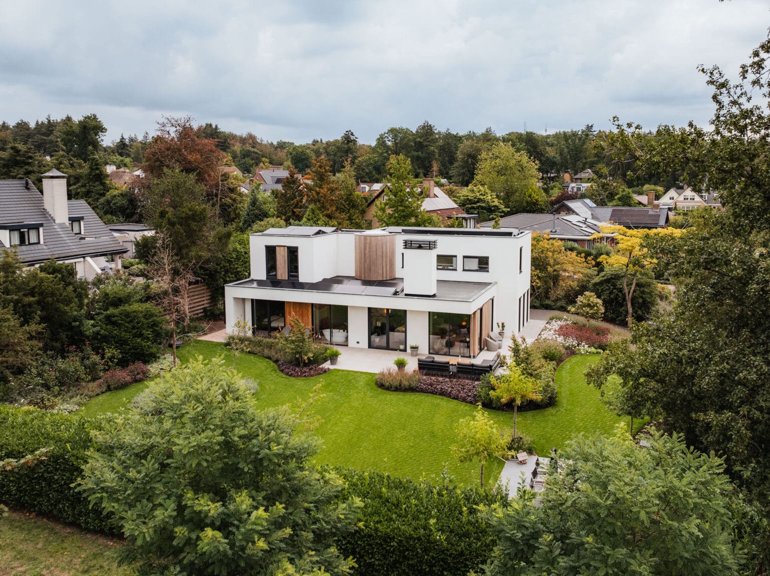 Luchtfoto van de vrijstaande witte villa in Leersum met tuin en bosrijke omgeving